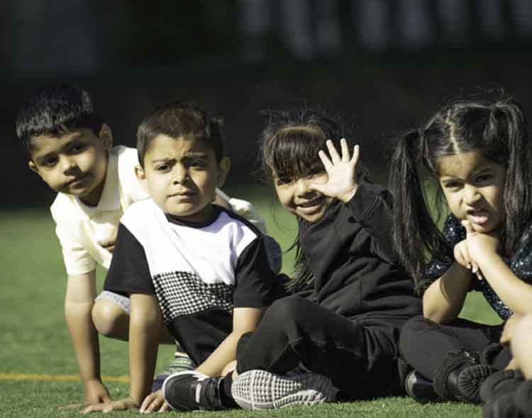  Group of children sat watching sports on a field