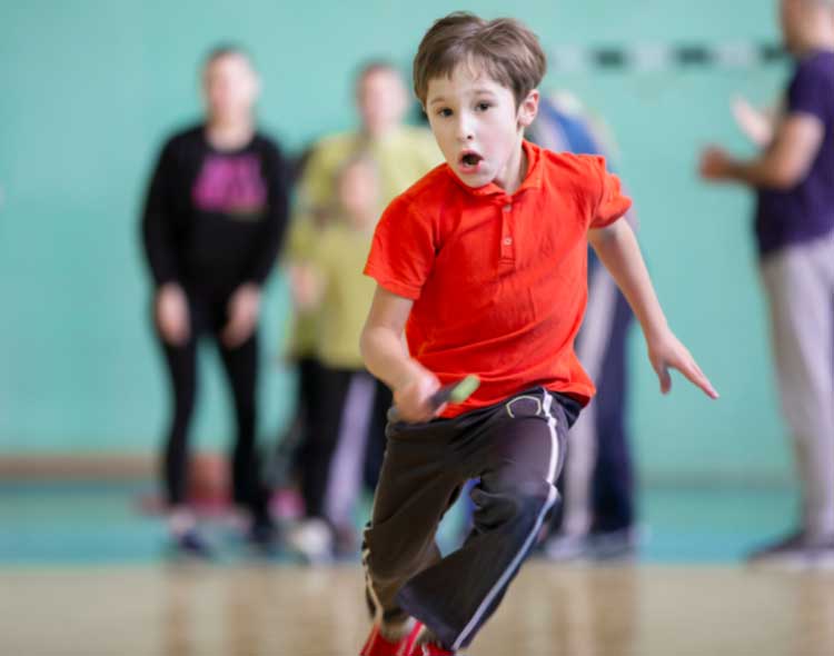Child running in sports hall - looking focused