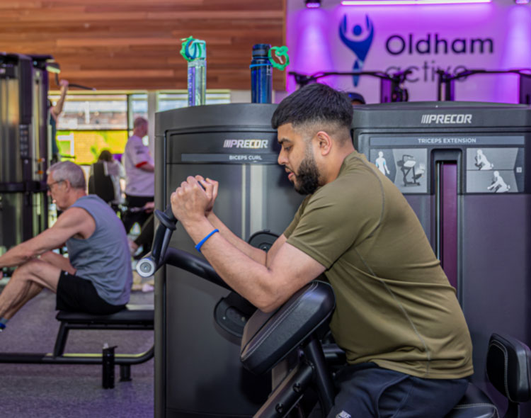 Man useing equipemnt at Oldham Active Gym seated side on